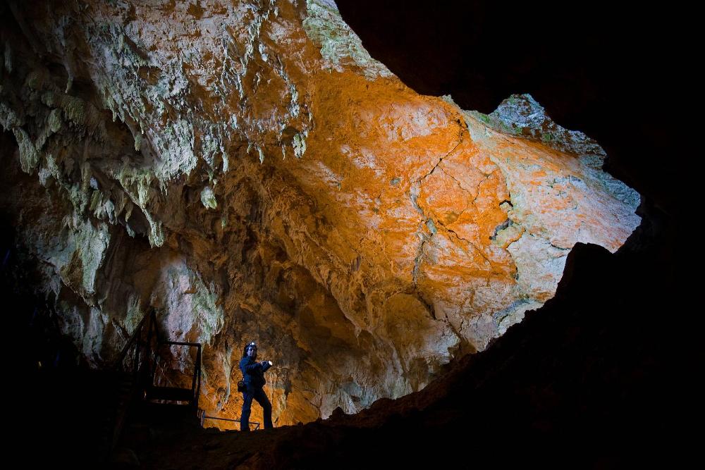 Fille avec une lampe de poche dans la grotte de Mendukilo